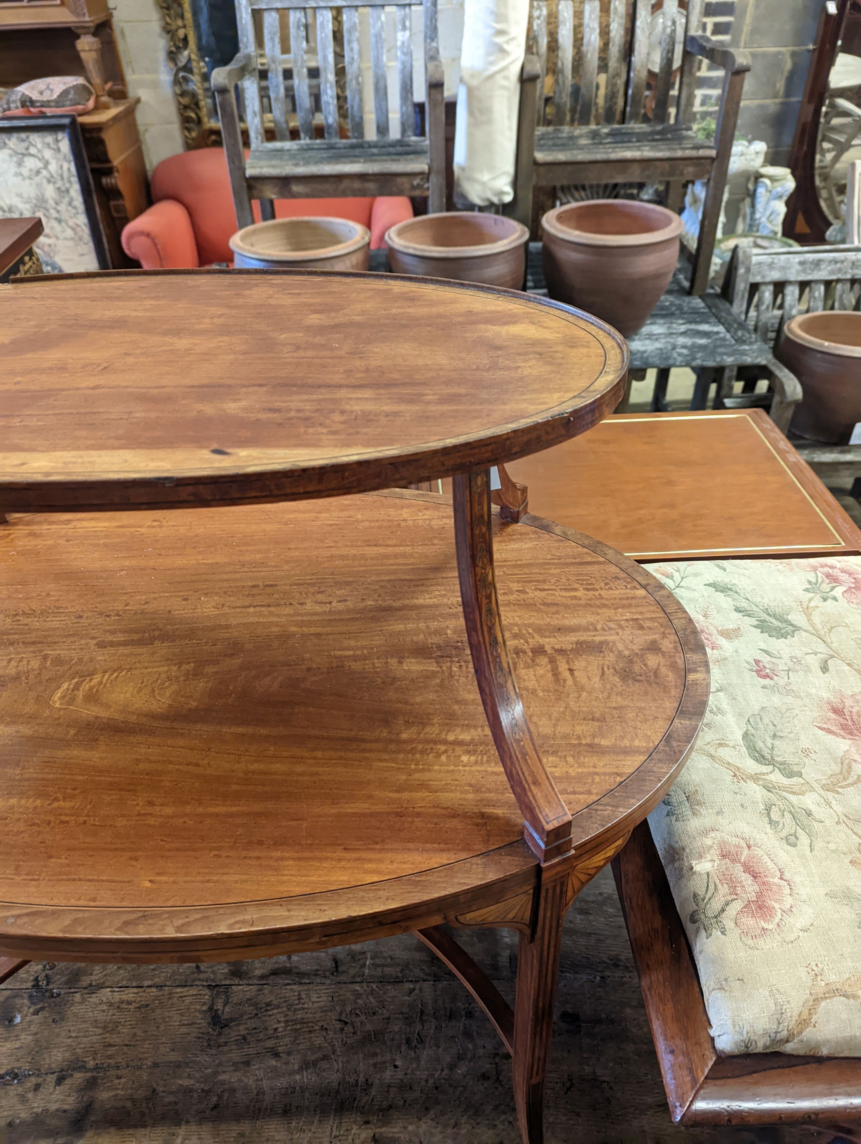 An Edwardian Sheraton revival oval inlaid satinwood two tier etagere, width 89cm, depth 55cm, height 77cm